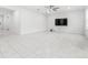 Spacious living room with tile flooring, ceiling fan, and large television at 1050 Michelangelo Ln, Winter Haven, FL 33884