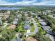 Aerial view showcasing a beautiful community, mature trees, and a serene blue lake in the background at 109 Lake Mariam Way, Winter Haven, FL 33884