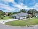 Aerial view of a blue home featuring a circular driveway, lush lawn, and well-maintained landscaping at 109 Lake Mariam Way, Winter Haven, FL 33884