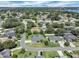 An elevated perspective of a home nestled within a lush, green residential neighborhood near a body of water at 109 Lake Mariam Way, Winter Haven, FL 33884