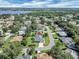 This aerial view shows property near a blue lake and surrounded by trees in a peaceful neighborhood at 109 Lake Mariam Way, Winter Haven, FL 33884