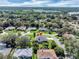 Aerial view of a single-Gathering home in a lush, green neighborhood with mature trees and well-maintained lawns at 109 Lake Mariam Way, Winter Haven, FL 33884