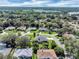 A sprawling aerial view of a neighborhood featuring lush green landscaping, mature trees, and a lake in the background at 109 Lake Mariam Way, Winter Haven, FL 33884