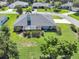 Aerial view of home with a screen enclosed patio overlooking a lush green lawn and landscaped garden at 109 Lake Mariam Way, Winter Haven, FL 33884