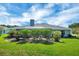 Backyard view with mature landscaping surrounding a screen enclosed patio and a lush lawn at 109 Lake Mariam Way, Winter Haven, FL 33884