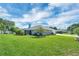 Expansive backyard featuring mature landscaping, a lush lawn, and a screen enclosed patio at 109 Lake Mariam Way, Winter Haven, FL 33884