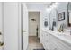 Bright bathroom boasts a double sink vanity, white cabinets, and a view into an adjacent room at 109 Lake Mariam Way, Winter Haven, FL 33884