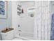 Bright bathroom features white subway tiles, shower with white ruffled curtain, and nautical decor at 109 Lake Mariam Way, Winter Haven, FL 33884