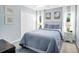 Cozy bedroom featuring a plush queen bed, soft blue walls, and ample natural light from two windows at 109 Lake Mariam Way, Winter Haven, FL 33884