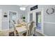 Dining room with white table and chairs near the doors that lead to an outdoor seating area at 109 Lake Mariam Way, Winter Haven, FL 33884