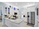 Bright kitchen featuring stainless steel appliances, granite countertops, with white cabinetry and large island at 109 Lake Mariam Way, Winter Haven, FL 33884
