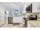 Bright kitchen with stainless steel appliances, granite countertops, and white cabinetry and adjacent breakfast nook at 109 Lake Mariam Way, Winter Haven, FL 33884