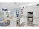 Open kitchen with white cabinets, island seating, stainless appliances, and adjacent dining area at 109 Lake Mariam Way, Winter Haven, FL 33884