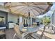 Screened lanai with dining and grilling area perfect for outdoor entertaining, shaded by large umbrella at 109 Lake Mariam Way, Winter Haven, FL 33884