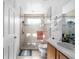 Bright bathroom featuring a glass shower, neutral tile, and a wooden vanity with sink at 110 Minniehaha Cir, Haines City, FL 33844