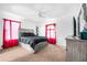 Inviting bedroom with a bed, neutral-toned furniture, and bright red curtains at 110 Minniehaha Cir, Haines City, FL 33844