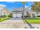 Well-kept home showcasing a two-car garage, arched windows, and a beautifully landscaped yard at 110 Minniehaha Cir, Haines City, FL 33844
