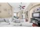 Spacious living room with sectional sofa, ceiling fan, and view of the dining area and staircase at 110 Minniehaha Cir, Haines City, FL 33844