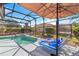Relaxing screened-in pool area with sun loungers, spa, and lush backyard views at 110 Minniehaha Cir, Haines City, FL 33844