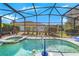 Beautiful screened pool features an attached spa, volleyball net, and view of the backyard at 110 Minniehaha Cir, Haines City, FL 33844