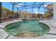 Sparkling in-ground pool and spa surrounded by a screened enclosure and lush landscaping at 110 Minniehaha Cir, Haines City, FL 33844