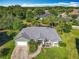 Aerial view of a green single-story home with a pool and a well-manicured lawn at 123 Evergreen Dr, Auburndale, FL 33823