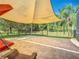 Spacious outdoor patio with shade sail, cozy seating, and iron fence overlooking a peaceful backyard at 123 Evergreen Dr, Auburndale, FL 33823