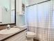 Bright bathroom features a vanity with a gray countertop, toilet, and shower with a polka dot shower curtain at 123 Evergreen Dr, Auburndale, FL 33823