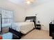 This cozy bedroom features carpeted floors, a ceiling fan, a window, and a comfortable bed at 123 Evergreen Dr, Auburndale, FL 33823