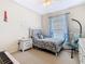 This cozy bedroom features carpeted floors, a ceiling fan, a window, a comfortable bed and a hanging chair at 123 Evergreen Dr, Auburndale, FL 33823