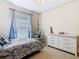 This cozy bedroom features carpeted floors, a ceiling fan, a window, a comfortable bed and a hanging chair at 123 Evergreen Dr, Auburndale, FL 33823
