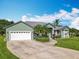 Charming single story home featuring lush landscaping, a two car garage, and a circular driveway at 123 Evergreen Dr, Auburndale, FL 33823