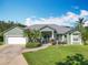 Charming single-story home boasts a manicured lawn and tidy landscaping, enhancing its curb appeal at 123 Evergreen Dr, Auburndale, FL 33823