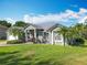 Landscaped front yard of a single-story home with palm trees and well-maintained green grass at 123 Evergreen Dr, Auburndale, FL 33823