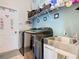 Functional laundry room with modern washer and dryer, sink, and storage at 123 Evergreen Dr, Auburndale, FL 33823
