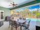 Screened patio with a dining set and a view of the sparkling pool and lush landscaping at 123 Evergreen Dr, Auburndale, FL 33823