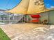 Large patio with brick pavers, sun shade, and outdoor seating, perfect for entertaining or relaxing at 123 Evergreen Dr, Auburndale, FL 33823