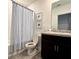 Bathroom with a dark vanity, a white toilet, and a blue and white shower curtain at 1363 Benevento Dr, Winter Haven, FL 33884