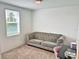 Bright bedroom featuring a tufted couch, a large window, and neutral-toned carpet at 1363 Benevento Dr, Winter Haven, FL 33884