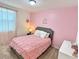 Charming bedroom with pink walls, crown accents, and comfortable furnishings at 1363 Benevento Dr, Winter Haven, FL 33884