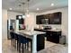 Modern kitchen featuring dark wood cabinets, stainless steel appliances, and pendant lighting at 1363 Benevento Dr, Winter Haven, FL 33884