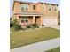 Inviting two-story home with a lush green lawn, cozy porch seating, and a convenient two-car garage at 1378 Fox Squirrel Dr, Davenport, FL 33897