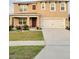 Charming two-story home featuring a well-maintained lawn, covered front porch, and attached two-car garage at 1378 Fox Squirrel Dr, Davenport, FL 33897