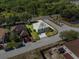 Aerial view of a green two-story home with a gray roof on a neatly maintained lot at 1800 Emily Dr, Winter Haven, FL 33884