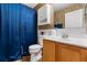 Bathroom featuring vanity with wood cabinets, a toilet, and a shower with a blue curtain at 1800 Emily Dr, Winter Haven, FL 33884