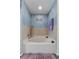 Bathroom featuring a soaking tub with tile surround and blue accent wall at 1800 Emily Dr, Winter Haven, FL 33884
