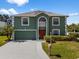 Charming two-story home with green exterior, white trim, neat lawn, and freshly paved driveway at 1800 Emily Dr, Winter Haven, FL 33884
