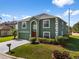 Charming two-story home with green exterior, white trim, neat lawn, and freshly paved driveway at 1800 Emily Dr, Winter Haven, FL 33884