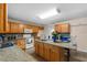 Open kitchen with a functional center island, wood cabinets, and granite countertops at 1800 Emily Dr, Winter Haven, FL 33884