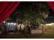 Backyard at night with string lights, a wooden fence, and lush greenery at 195 E Vine St, Bartow, FL 33830